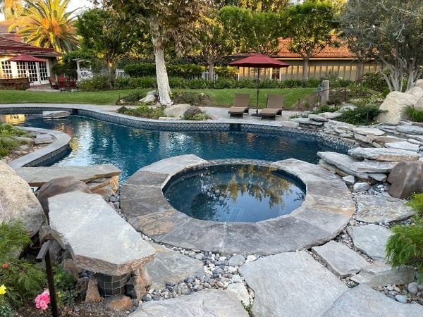 natural rock and stone pavers surrounding a freeform pool