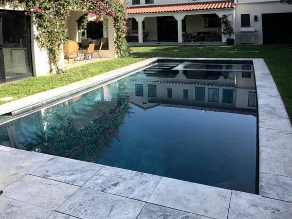 natural stone pavers and grass surrounding rectilinear pool