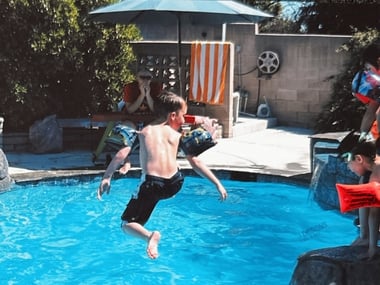 kid jumping on a pool