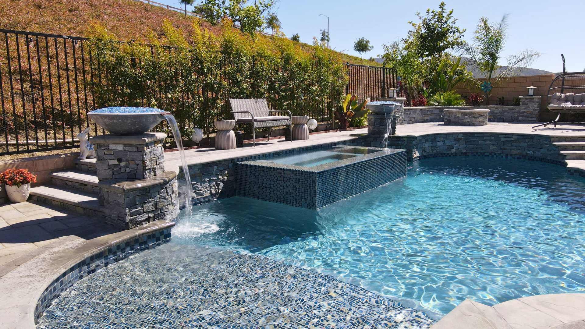 a glass-tiled raised spa, water features, and a spacious patio area 