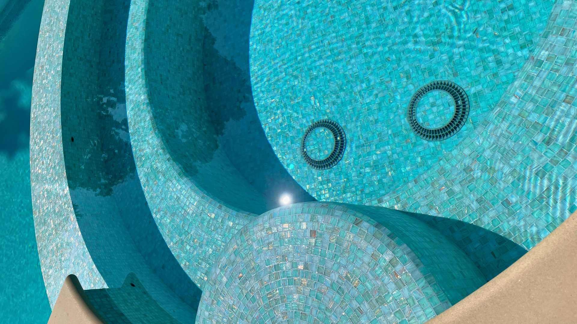 Close-up of the seating area inside a spa, showcasing light blue glass tiles.