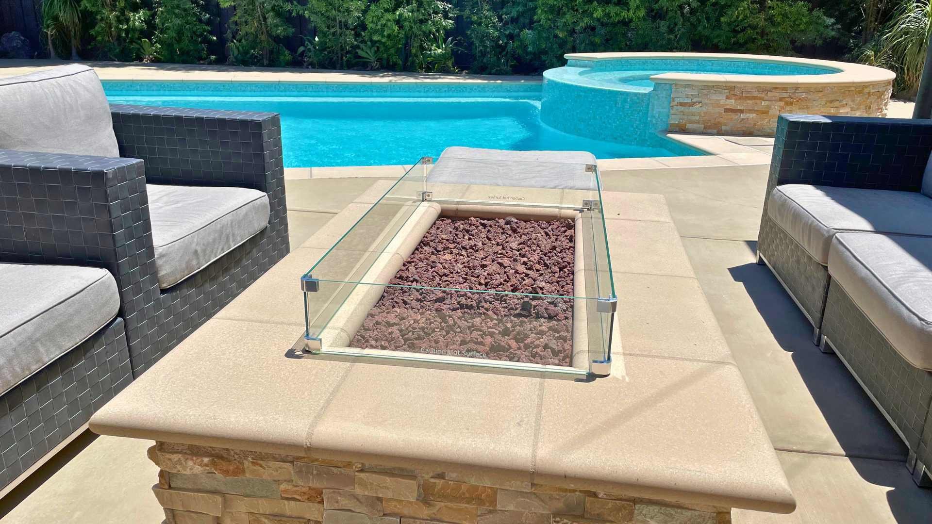 View of a fire-pit with a pool in the background
