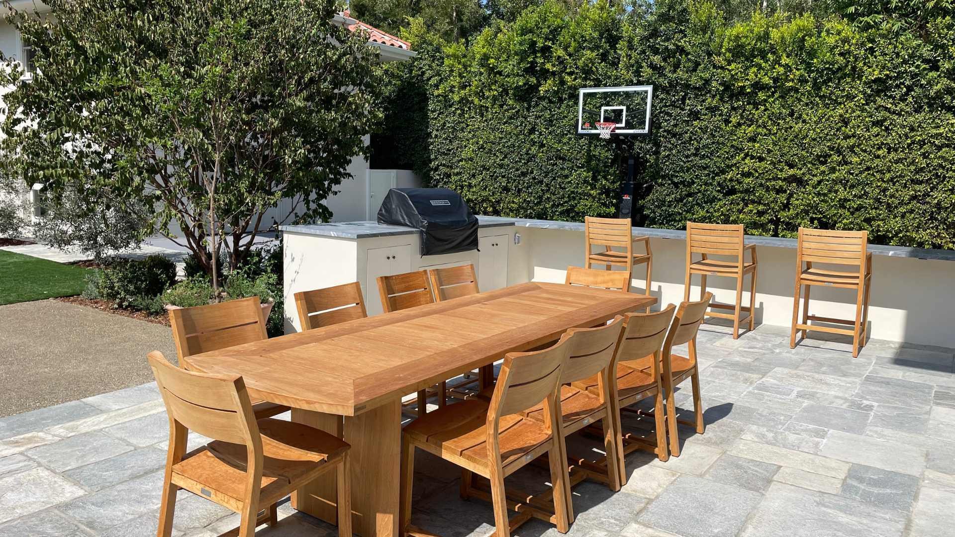 outdoor dining area with wood furniture and BBQ