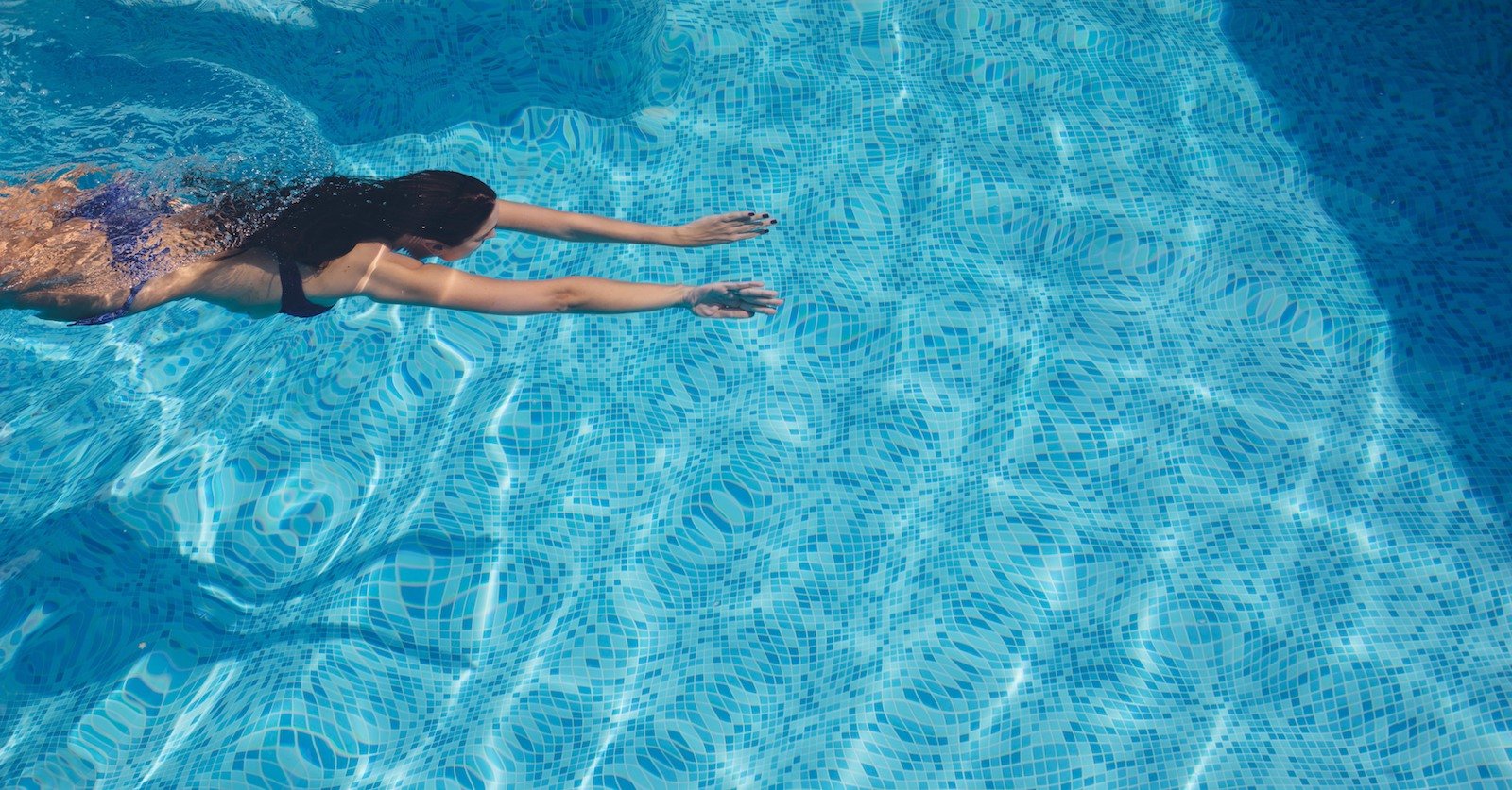 girl swimming across pool copy