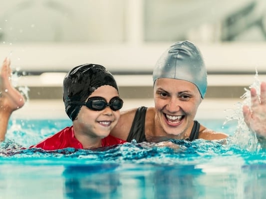 A child learning to swim in a private lesson