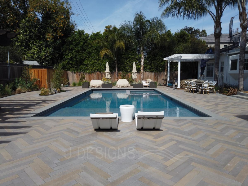 J Designs' swimming pools and spas feature a modern, rectangular design with comfortable lounge areas and chic herringbone paver decks.