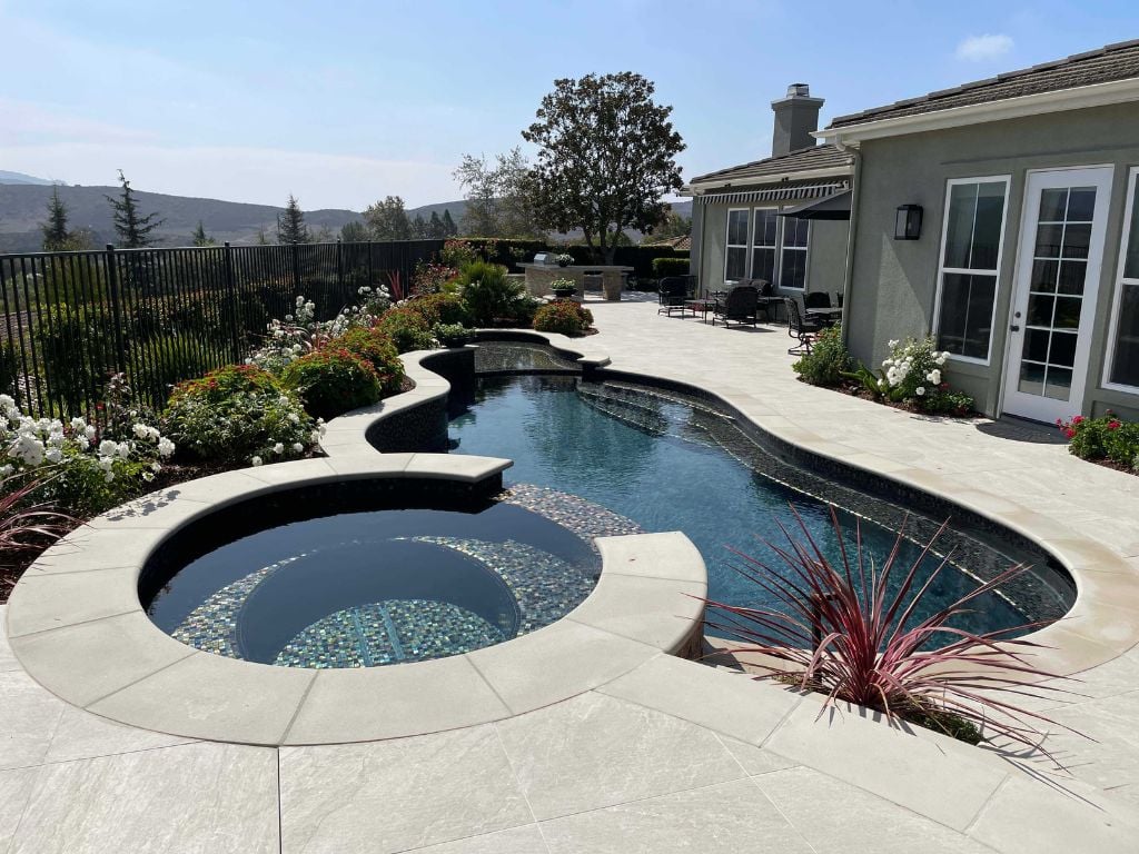 Revamp your pool & spa with JDesigns: Glass tile spa, tanner ledge, and benches, topped off with a stunning hematite wet edge finish.