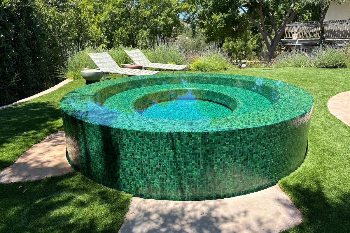 Close-up of a round overflow perimeter spa, fully tiled with a raised design, located in a Calabasas property.