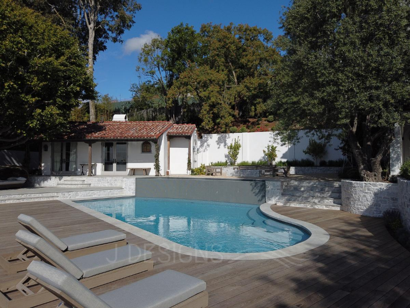 Revitalize your space with JDesigns' luxury pool & spa renovations, featuring wood decks inspired by the French countryside's charming style.