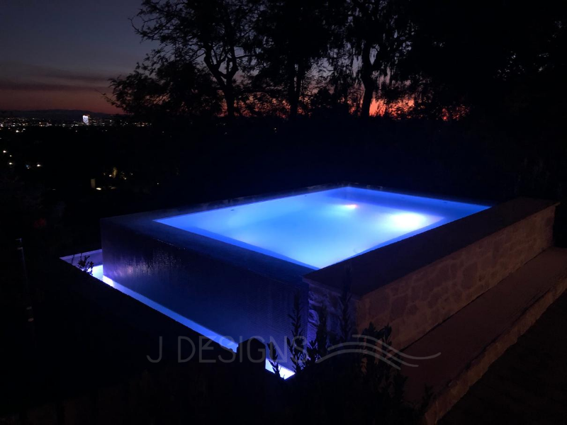 Experience unparalleled relaxation in our overflow perimeter spa, offering breathtaking views of the Bel Air hills - only at JDesigns Pools & Spa.