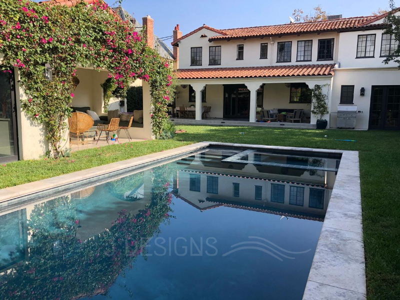 Transform your backyard with JDesigns' classic Hollywood glamour-inspired pool & spa, featuring a rectilinear design amidst stunning landscaping.